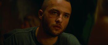 Movie still from “The Enforcer” (2022), directed by Richard Hughes – A person with a shaved head; Close Up shot, Low angle