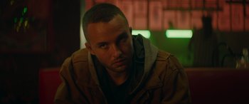 Movie still from “The Enforcer” (2022), directed by Richard Hughes – A person wearing a brown jacket; Close Up shot, Low angle