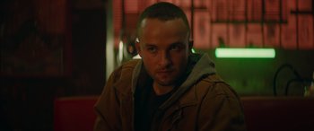 Movie still from “The Enforcer” (2022), directed by Richard Hughes – A person wearing a brown jacket; Close Up shot, Low angle