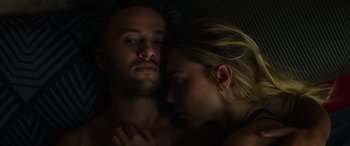 Movie still from “The Enforcer” (2022), directed by Richard Hughes – A man and a woman laying in bed together; Close Up shot, Overhead angle
