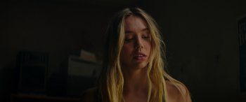 Movie still from “The Enforcer” (2022), directed by Richard Hughes – A beautiful young woman with long blonde hair; Close Up shot, Low angle