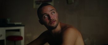 Movie still from “The Enforcer” (2022), directed by Richard Hughes – A man with a shaved head looking up at the ceiling; Close Up shot, Low angle