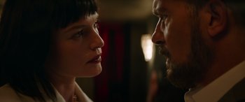 Movie still from “The Enforcer” (2022), directed by Richard Hughes – A man and a woman face to face in a dark room; Close Up shot, Low angle