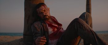 Movie still from “The Enforcer” (2022), directed by Richard Hughes – A man with blood all over his face and chest; Medium shot, Low angle