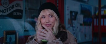 Movie still from “The Enforcer” (2022), directed by Richard Hughes – A woman holding an apple in her hands; Close Up shot, Over the shoulder angle