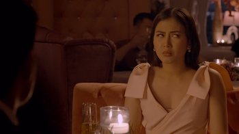 Movie still from “The Entitled” (2022), directed by Theodore Boborol – A woman sitting at a table with a candle in front of her; Close Up shot, Over the shoulder angle