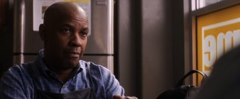 Movie still from “The Equalizer” (2014), directed by Antoine Fuqua – A man in an apron sitting in front of a refrigerator; Close Up shot, Over the shoulder angle