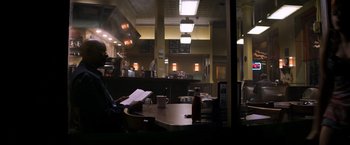 Movie still from “The Equalizer” (2014), directed by Antoine Fuqua – A person sitting at a table in a restaurant; Wide shot, Over the shoulder angle