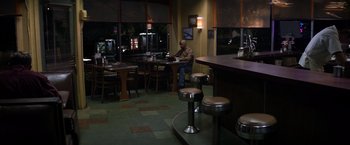 Movie still from “The Equalizer” (2014), directed by Antoine Fuqua – A man sitting at a table in front of a window; Wide shot, High angle