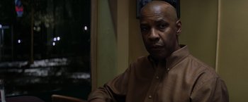 Movie still from “The Equalizer” (2014), directed by Antoine Fuqua – A man in a brown shirt is looking at the camera; Close Up shot, Over the shoulder angle