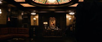 Movie still from “The Equalizer” (2014), directed by Antoine Fuqua – A man sitting at a desk in front of a painting; Wide shot, Low angle