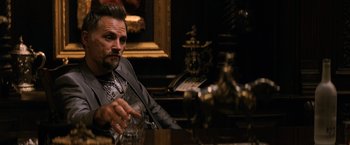 Movie still from “The Equalizer” (2014), directed by Antoine Fuqua – A man sitting at a table with a glass of whiskey; Close Up shot, Over the shoulder angle