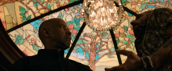 Movie still from “The Equalizer” (2014), directed by Antoine Fuqua – A man standing in front of a stained - glass window; Medium shot, Low angle