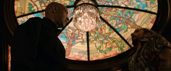 Movie still from “The Equalizer” (2014), directed by Antoine Fuqua – A man standing in front of a stained - glass window; Medium shot, Low angle