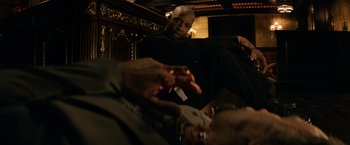 Movie still from “The Equalizer” (2014), directed by Antoine Fuqua – A man sitting on top of a wooden bench; Medium shot, Low angle