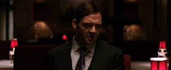 Movie still from “The Equalizer” (2014), directed by Antoine Fuqua – A person wearing a suit and tie; Close Up shot, Over the shoulder angle