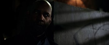 Movie still from “The Equalizer” (2014), directed by Antoine Fuqua – A man with a bald head is standing in a dark room; Close Up shot, Over the shoulder angle