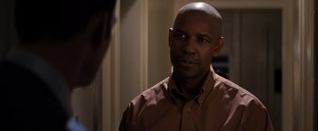 Movie still from “The Equalizer” (2014), directed by Antoine Fuqua – A bald man in a brown shirt looking at a mirror; Close Up shot, Over the shoulder angle