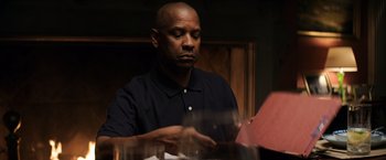 Movie still from “The Equalizer” (2014), directed by Antoine Fuqua – A man sitting at a dinner table looking down; Medium shot, Over the shoulder angle