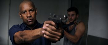 Movie still from “The Equalizer” (2014), directed by Antoine Fuqua – Two men are holding guns in a room; Medium shot, Low angle