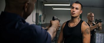 Movie still from “The Equalizer” (2014), directed by Antoine Fuqua – A man holding a gun in front of another man in a room; Medium shot, Over the shoulder angle