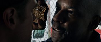 Movie still from “The Equalizer” (2014), directed by Antoine Fuqua – A man holding onto a police officer's badge; Close Up shot, Over the shoulder angle