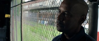 Movie still from “The Equalizer” (2014), directed by Antoine Fuqua – A person in front of a chain link fence; Close Up shot, Low angle