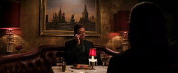 Movie still from “The Equalizer” (2014), directed by Antoine Fuqua – A man sitting at a table talking on a cell phone; Medium shot, Over the shoulder angle