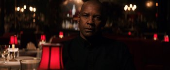 Movie still from “The Equalizer” (2014), directed by Antoine Fuqua – A man in a black shirt is in the dark; Close Up shot, Over the shoulder angle