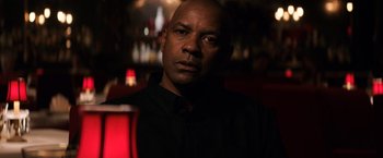 Movie still from “The Equalizer” (2014), directed by Antoine Fuqua – A man in a black shirt is in the dark; Close Up shot, Over the shoulder angle