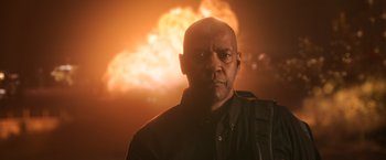 Movie still from “The Equalizer” (2014), directed by Antoine Fuqua – A bald man with a black shirt and a black backpack; Medium shot, Low angle