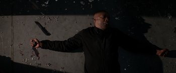 Movie still from “The Equalizer” (2014), directed by Antoine Fuqua – A man in a black shirt is standing in front of a wall; Medium shot, Overhead angle