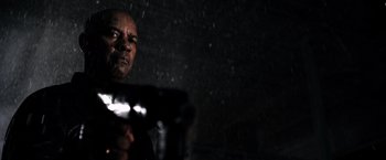 Movie still from “The Equalizer” (2014), directed by Antoine Fuqua – A man holding a gun while standing in the rain; Close Up shot, Low angle