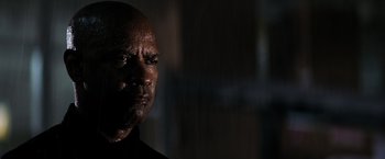 Movie still from “The Equalizer” (2014), directed by Antoine Fuqua – A bald man with a black shirt is looking at the camera; Close Up shot, Low angle
