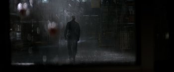 Movie still from “The Equalizer” (2014), directed by Antoine Fuqua – A man standing in the rain in front of a building; Extreme Wide shot, Low angle