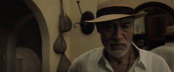 Movie still from “The Equalizer 3” (2023), directed by Antoine Fuqua – An older man wearing a straw hat in front of a wall; Close Up shot, Low angle
