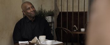 Movie still from “The Equalizer 3” (2023), directed by Antoine Fuqua – A man sitting at a table with a cup of coffee; Close Up shot, Over the shoulder angle