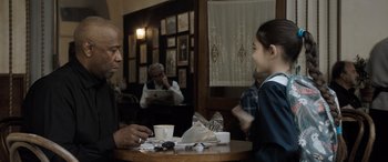 Movie still from “The Equalizer 3” (2023), directed by Antoine Fuqua – Two people sitting at a table in a restaurant; Medium shot, Over the shoulder angle