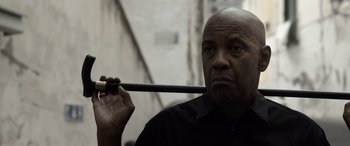 Movie still from “The Equalizer 3” (2023), directed by Antoine Fuqua – An older man holding a sword up to his face; Close Up shot, Low angle