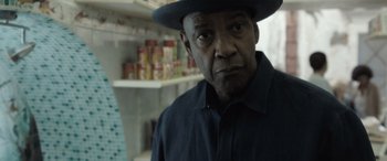 Movie still from “The Equalizer 3” (2023), directed by Antoine Fuqua – An older man wearing a hat in front of a shelf; Close Up shot, Over the shoulder angle