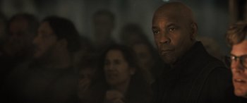 Movie still from “The Equalizer 3” (2023), directed by Antoine Fuqua – A group of people sitting in a dark room; Close Up shot, Low angle