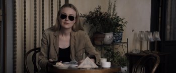 Movie still from “The Equalizer 3” (2023), directed by Antoine Fuqua – A woman sitting at a table with a plate of food; Medium shot, High angle