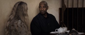 Movie still from “The Equalizer 3” (2023), directed by Antoine Fuqua – A man sitting at a table next to a woman; Medium shot, Over the shoulder angle