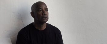 Movie still from “The Equalizer 3” (2023), directed by Antoine Fuqua – A man in a black shirt is looking to the side; Close Up shot, Low angle