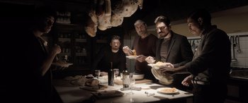 Movie still from “The Equalizer 3” (2023), directed by Antoine Fuqua – A group of men sitting at a table eating food; Wide shot, Low angle