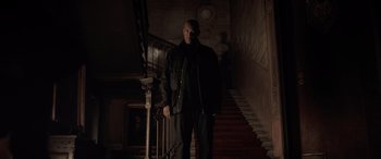 Movie still from “The Equalizer 3” (2023), directed by Antoine Fuqua – A man standing on the stairs in a dark room; Wide shot, Low angle