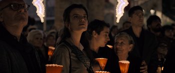 Movie still from “The Equalizer 3” (2023), directed by Antoine Fuqua – A group of people standing next to each other holding lit candles; Medium shot, Low angle