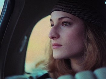 Movie still from “The Evil Dead” (1981), directed by Sam Raimi – A person sitting in a car; Close Up shot, Low angle