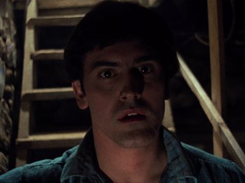 Movie still from “The Evil Dead” (1981), directed by Sam Raimi – A person in a room with stairs; Close Up shot, Low angle