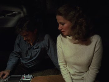 Movie still from “The Evil Dead” (1981), directed by Sam Raimi – A man and a woman sitting next to each other; Medium shot, High angle